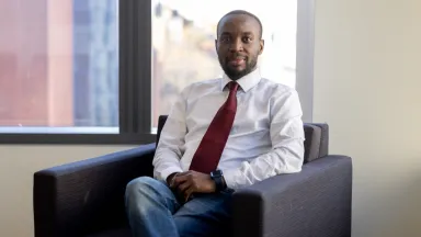 Aanu Oluwande, PhD Candidate, Management, sitting in chair by window