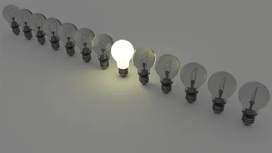 A row of lightbulbs, only one near the middle is lit