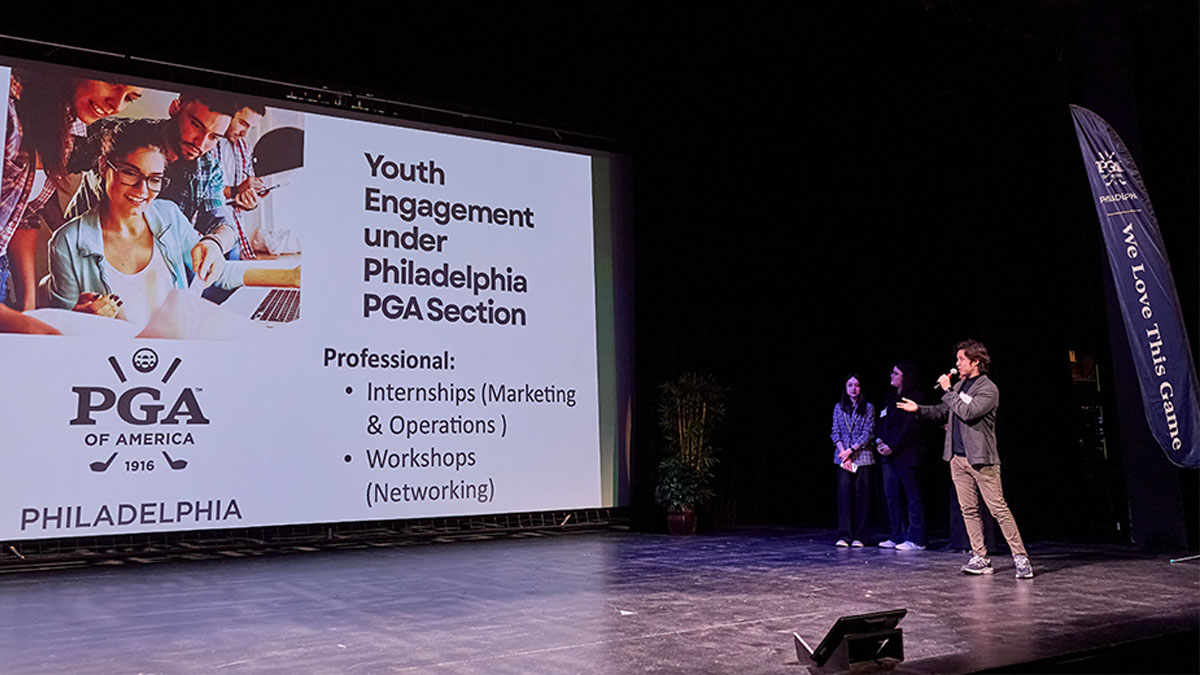 A large presentation screen on the left with the PGA of Philadelphia logo, a stock photo of students working at a computer and text reading Youth Engagement Under Philadelphia PGA Section, with a group of students visible at right