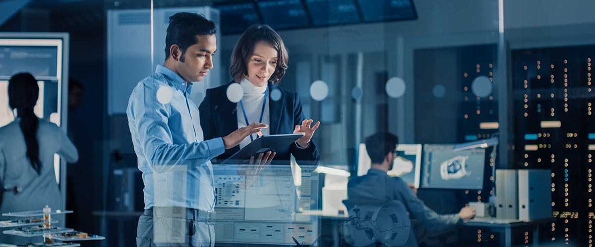 two business leaders in a room with multiple data visualisations