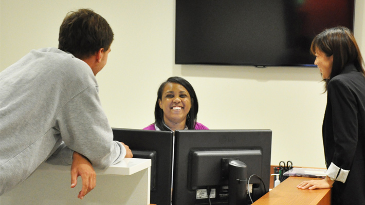 students chatting at the front desk in career services