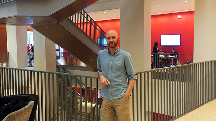  Zack Cooper, PhD stands in Gerri C. LeBow Hall