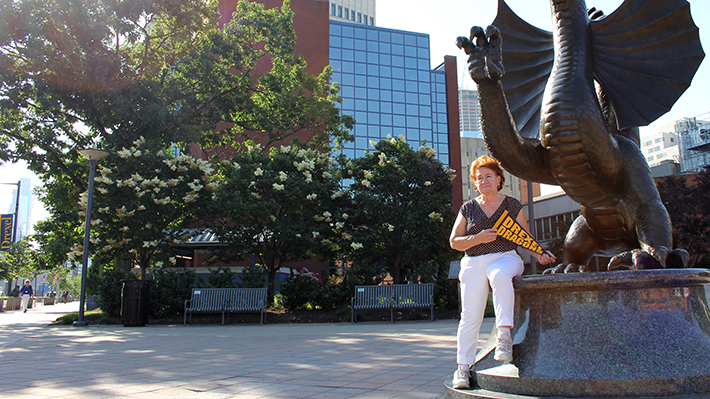 Bernardine Rzucidlo  in front of dragon statue
