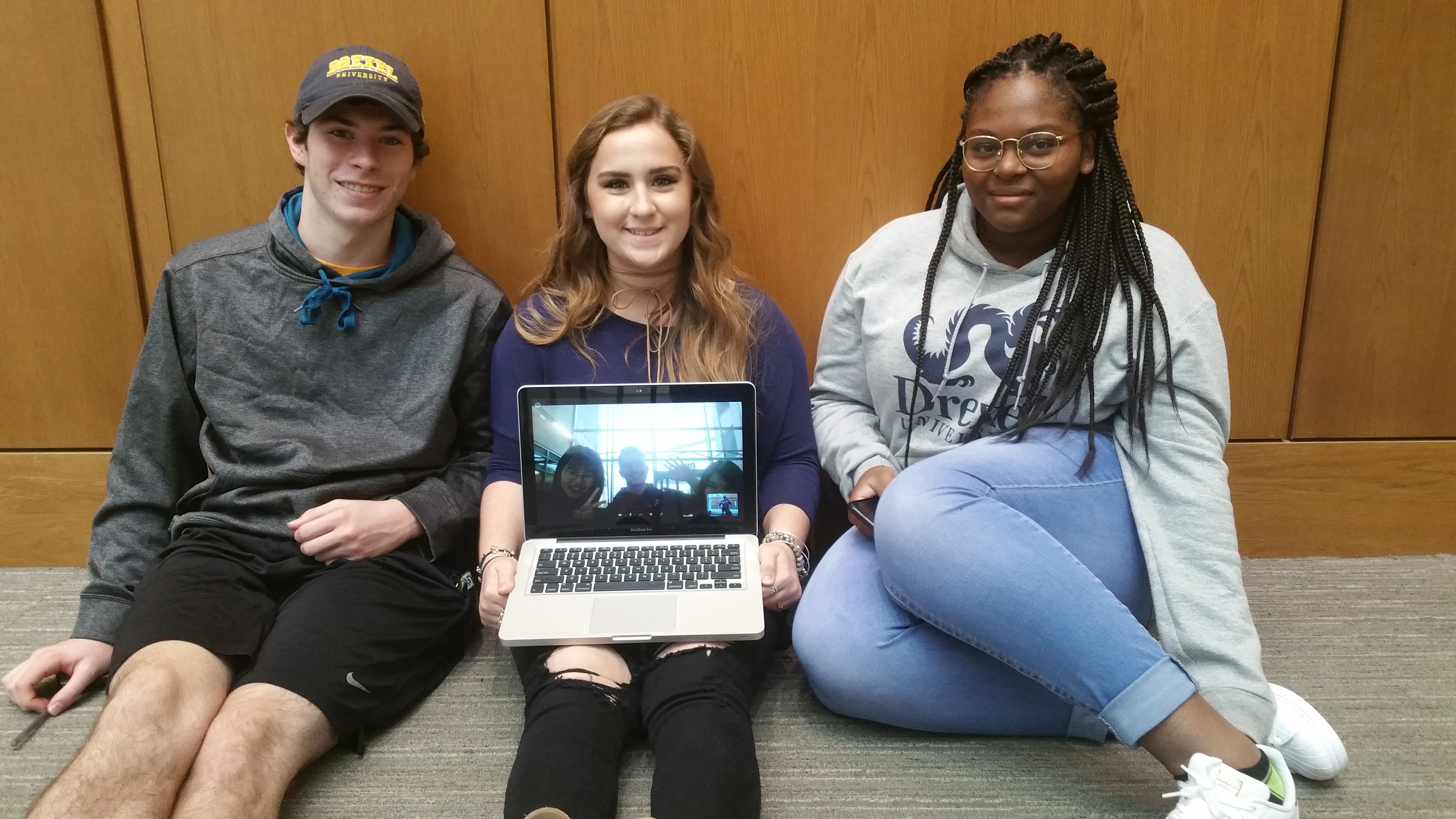 Students in second floor hallway with laptop