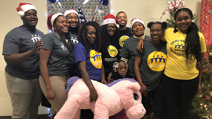 LeBow BRIDGE students pose with gifts they collected 