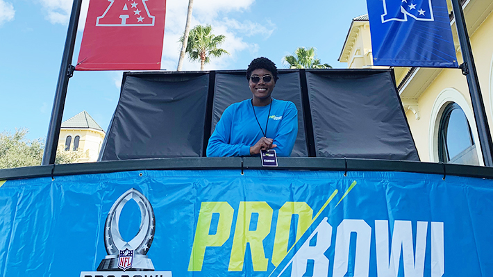 Arian Palmer stands behind Pro Bowl sign