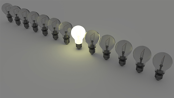 A row of lightbulbs, only one near the middle is lit A row of lightbulbs, only one near the middle is lit