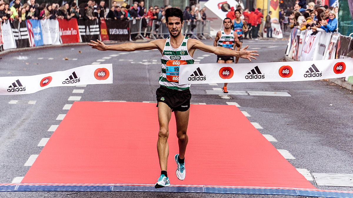 Male runner crossing the finish line at the end of a race