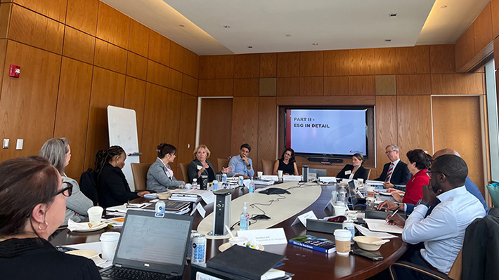 Directors Academy Participants gather around a table in a boardroom