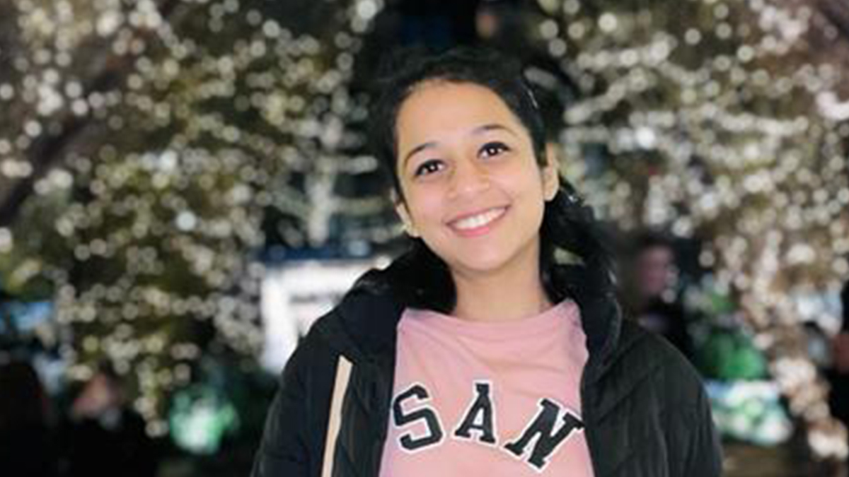 Young woman standing against holiday decoration backdrop