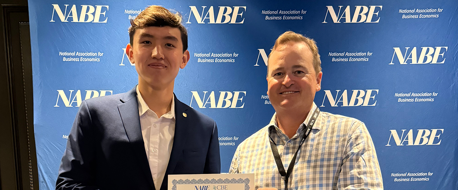 A young man and an older man holding a certificate
