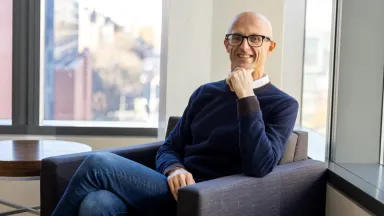 Headshot of Marco Airaudo, PhD, Professor of Economics sitting in chair in front of window