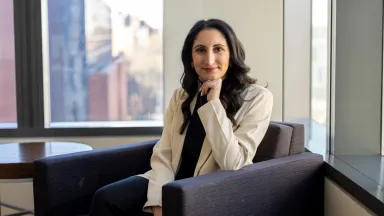 Headshot of Liza Barnes, PhD, Assistant Professor of Management sitting in chair in front of window