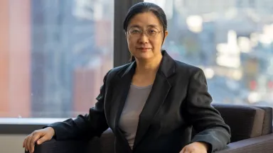 Headshot of Qizhi Dai, PhD, Associate Professor of Decision Sciences & MIS sitting in chair in front of window