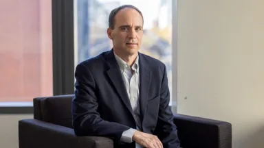 Headshot of Christopher Gaffney, PhD, Associate Clinical Professor of Decision Sciences & MIS sitting in chair in front of window