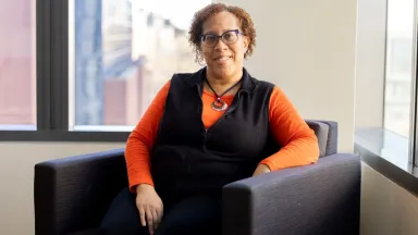 Headshot of Michele Sykes, Economics Department Manager sitting in chair in front of window