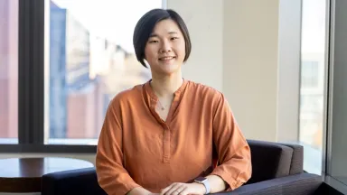 Landscape headshot of Yin Zhang, PhD Candidate, Economics sitting in chair