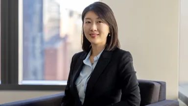 Seojin Kim, PhD, Assistant Professor of Management sitting in chair in front of window