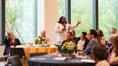 A woman stands to address the audience