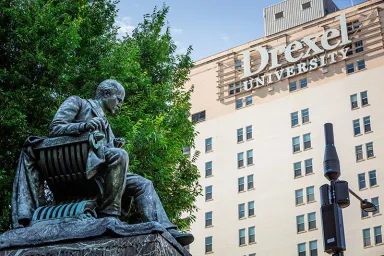Statue in front of LeBow hall with Drexel University visible in the background