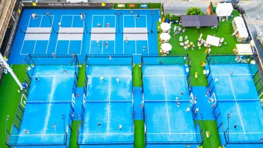 Blue pickleball and tennis courts with green space visible in between