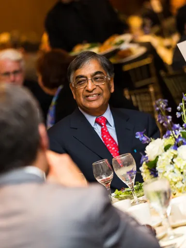 Raj Gupta smiles while conversing with guests during a Directors Dialogue event