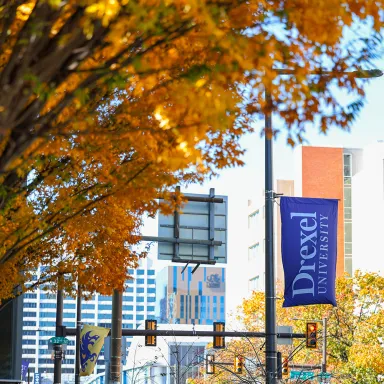 Beautiful fall foliage on Drexel's Philadelphia campus with a Drexel University banner in the background.