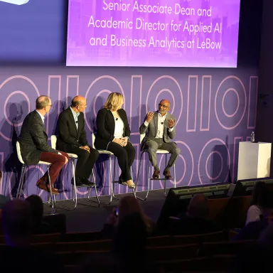 Academic Director for Applied AI and Business Analytics at LeBow on stage during the Precisely Trust event.