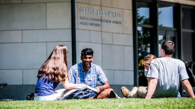 Students talking on the lawn outside of Gerri C. LeBow Hall