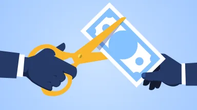 Hand holding scissors to cut banknote