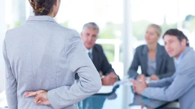 Businesswoman with fingers crossed behind her back