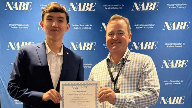 A young man and an older man holding a certificate