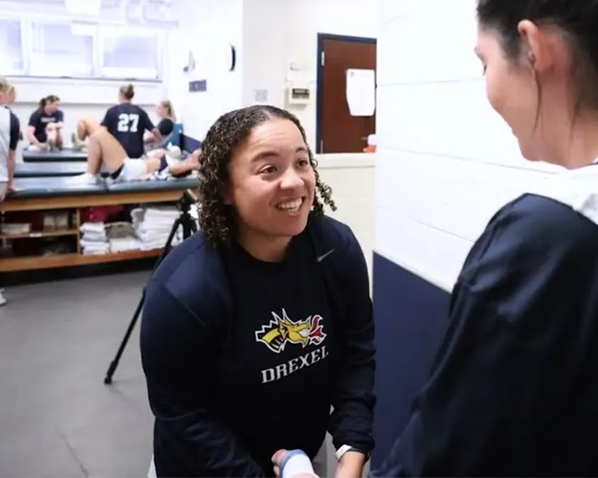 Cayla Williams works with student as an athletic trainer.