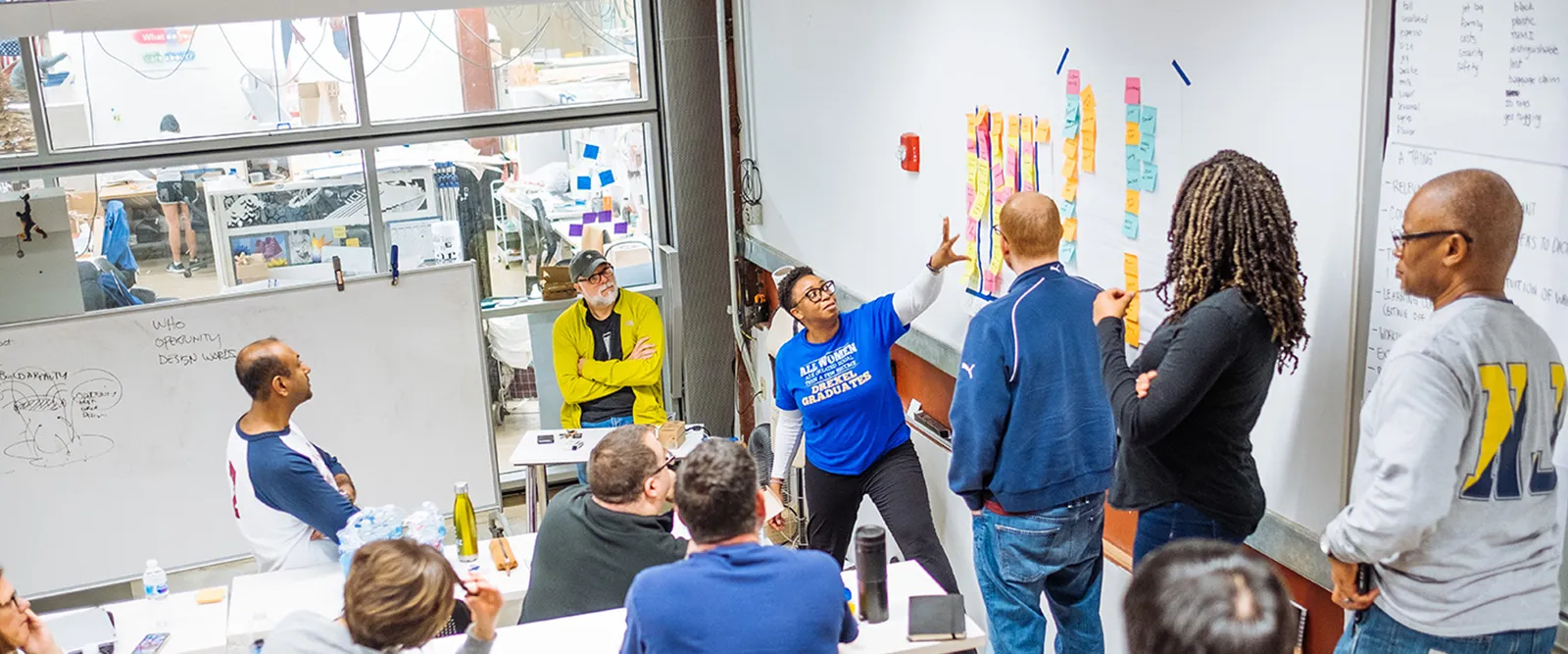 A group of graduate students reviewing post-it notes as part of an ideation workshop
