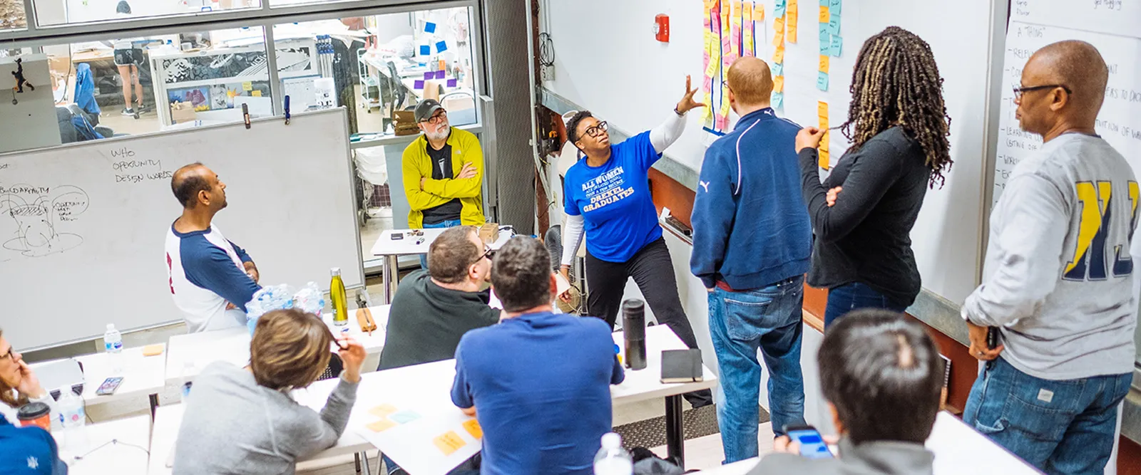 A group of graduate students reviewing post-it notes as part of an ideation workshop