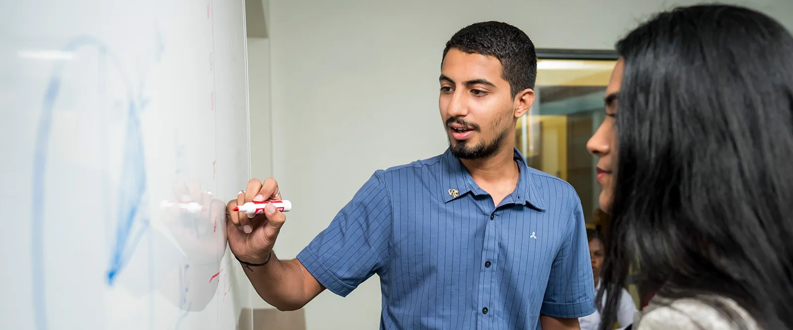 Drexel LeBow accounting students collaborating at a whiteboard.