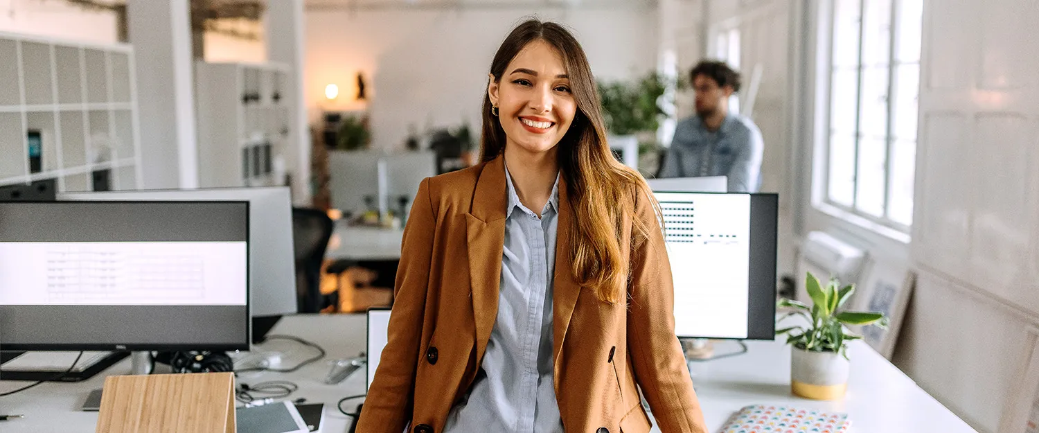 An entrepreneur smiles from inside their office.