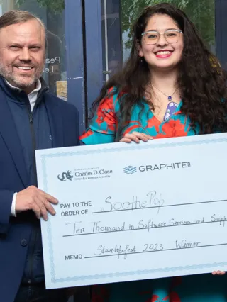 Close staff present student entrepreneurs with a $10,000 check to support their startup