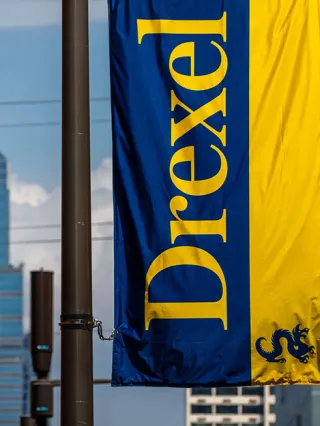 a drexel banner in front of the Philadelphia skyline
