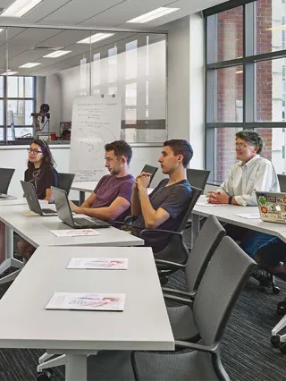 students listen attently as a professor explains key concepts during a class
