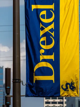a drexel banner in front of the Philadelphia skyline