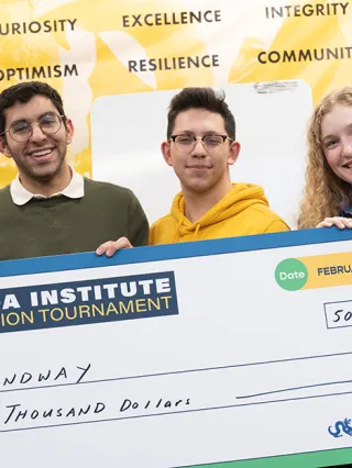 Student entrepreneurs pose with a check for $5,000 in funding.